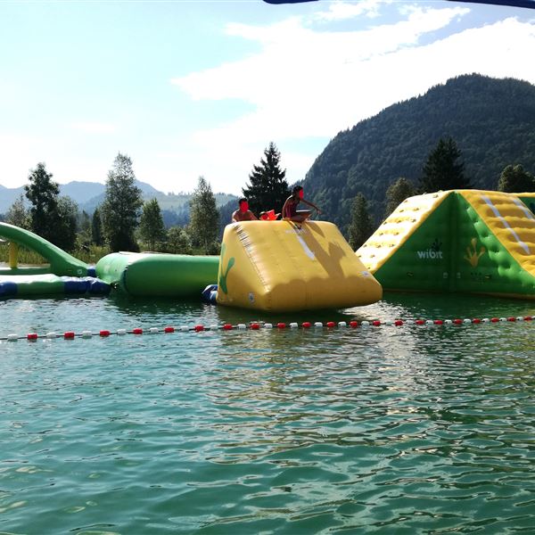 Ein Badespaß mit aufblasbaren Wasserspielgeräten im Walchsee. MIt der personalisierten Gästekarte erhalten sie den Eintritt zum Badebereich und zum Wasserpark gratis