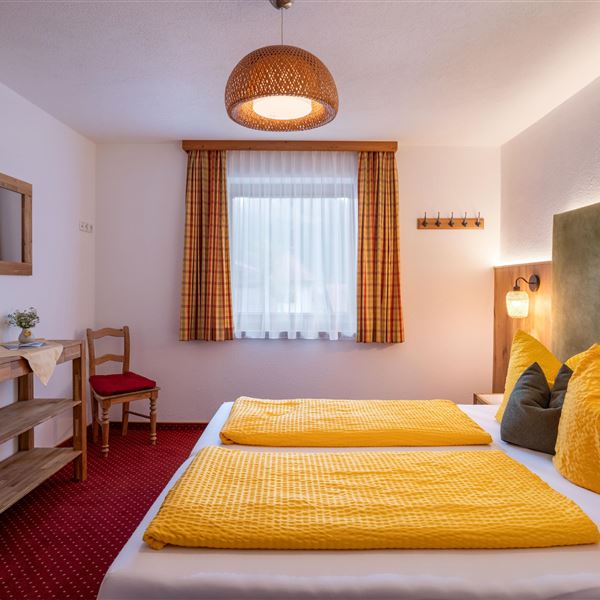 Ein helles Zimmer im Erdgeschoß mit Doppelbett 200x210. Fliegengitter und abdunkelnden Vorhängen.